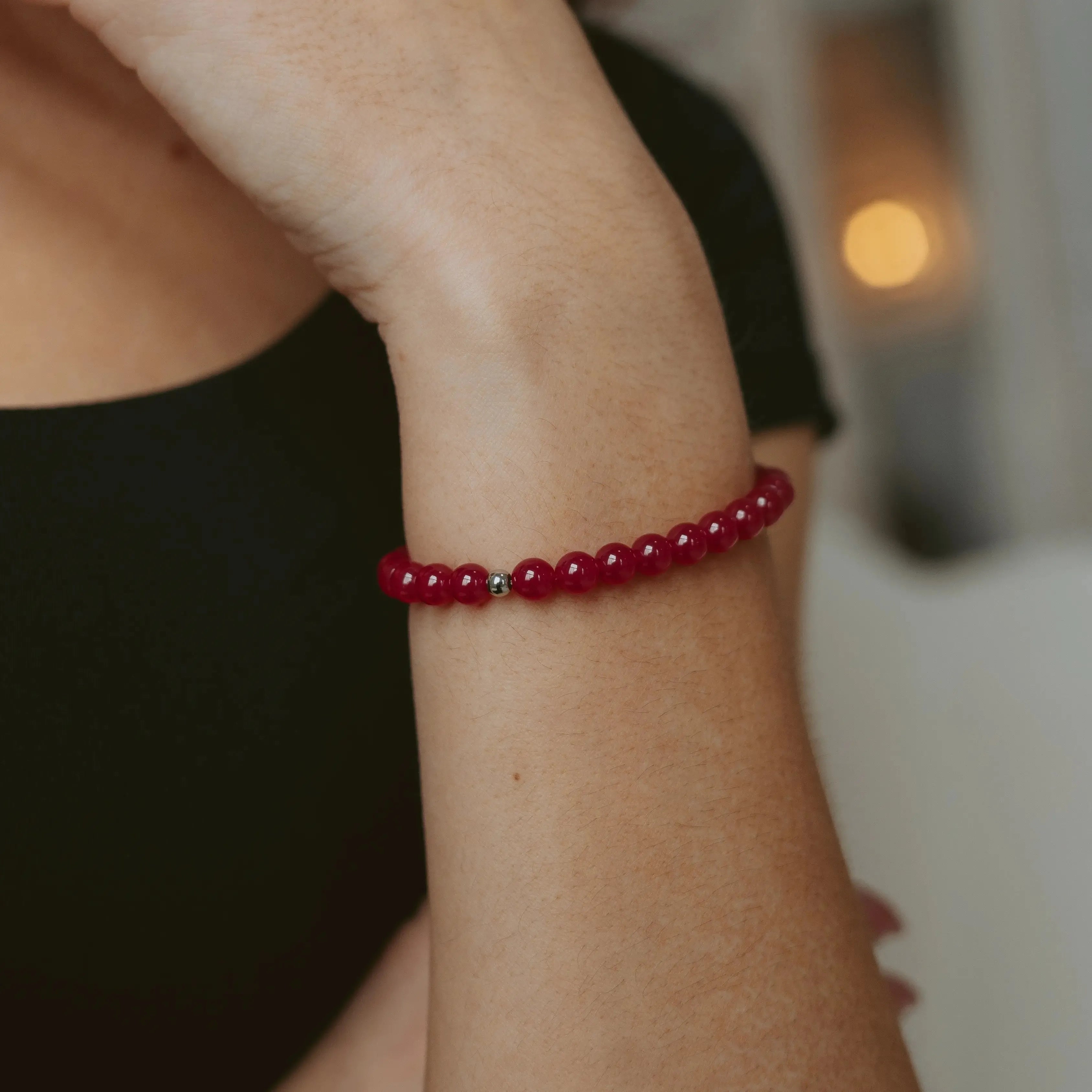 Red ruby 6mm beaded bracelet with silver accent beads and a BOLDN logo charm, displayed on a white background