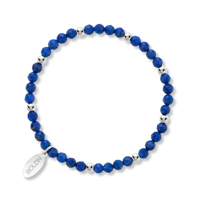 Blue beaded bracelet with silver accents on a white background