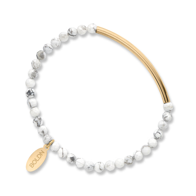 Bracelet with white beads and gold accents on a white background